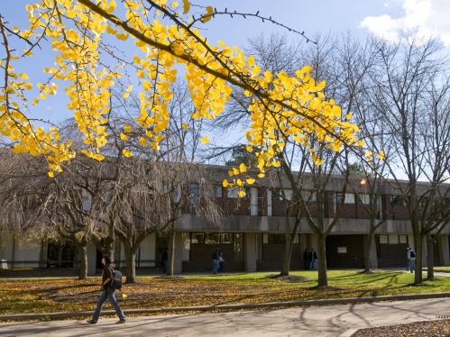 Student walks in front of Lucy Stone Hall on Livingston Campus